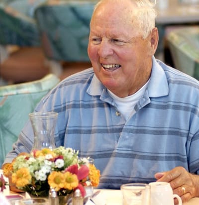 Older man enjoying a meal in the dining room.