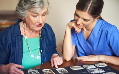 Staff member engaging with a resident over photos.