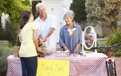 Residents hosting a yard sale with visitors.