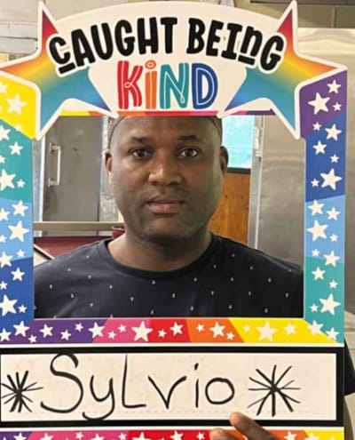 Resident holding a 'Caught Being Kind' sign.