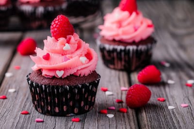 Cupcakes with pink frosting and raspberries
