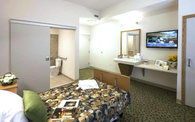 Cozy resident room with bed and television.