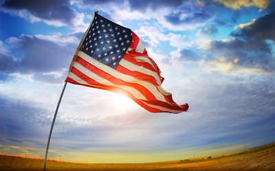 Waving American flag against a sunset