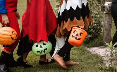 Children in costumes with pumpkin buckets