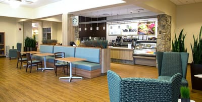 Modern dining area with seating and a café counter.