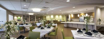 Dining room setup with tables and floral decorations.