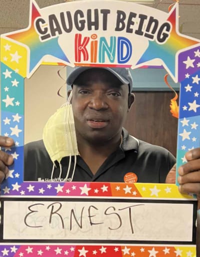 Resident holding a 'Caught Being Kind' sign