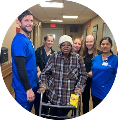 Staff assisting a resident in a hallway