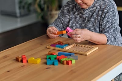 Senior woman playing with colorful building blocks