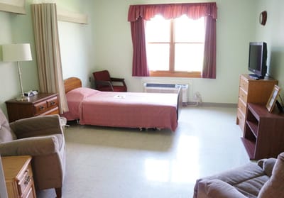 A comfortable resident room with a bed and furnishings