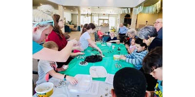 Residents and children engaging in a creative activity together