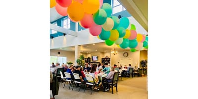 Residents enjoying a festive gathering with colorful balloons