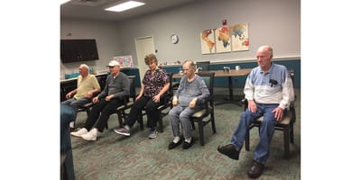 Residents participating in a seated activity in a common area