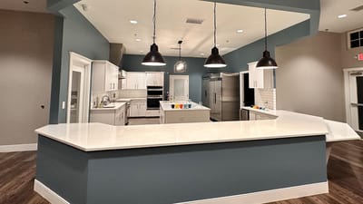 Modern kitchen area with large countertop and appliances