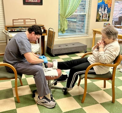 Staff member providing foot care to a resident