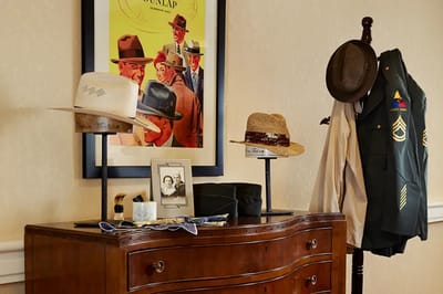 Display of vintage hats and military uniform in a common area
