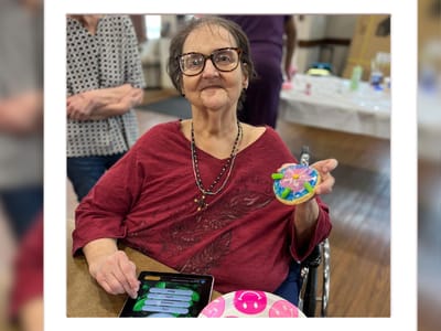 Resident enjoying a decorated cookie in a communal space