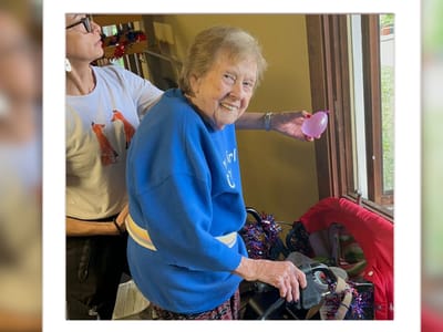 Resident smiling while engaging with staff member