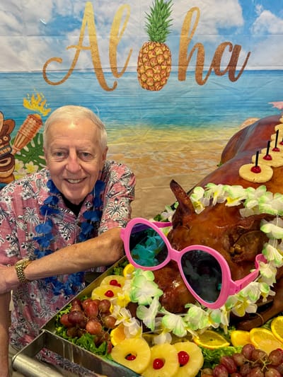 Resident celebrating with a pig roast at a festive party