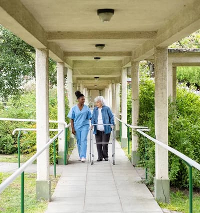 Staff assisting a resident in an outdoor walkway