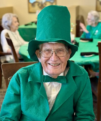 A resident dressed in green smiling during an activity