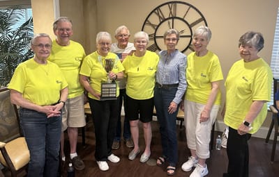 Residents celebrating with a trophy in a common area