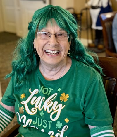 Resident celebrating with a green wig and festive shirt