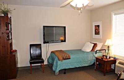 Cozy interior of a resident's room with bed and TV