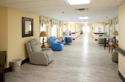 A hallway with seating areas in a senior living facility