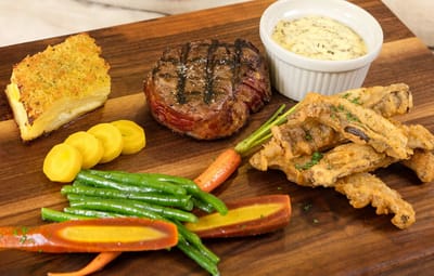 Plated meal with steak, vegetables, and sauce