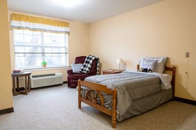 Cozy resident room with a bed and chair
