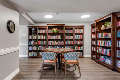 A cozy library with bookshelves and a table