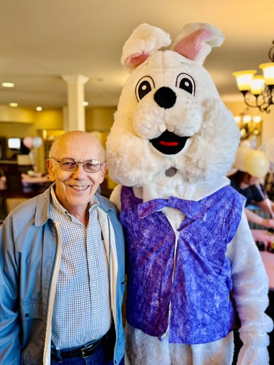 Resident posing with a mascot during a celebration