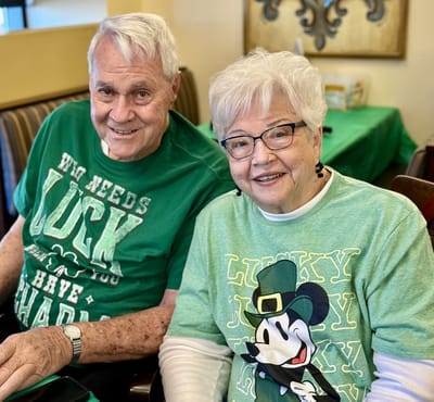Two seniors celebrating St. Patrick's Day in festive attire