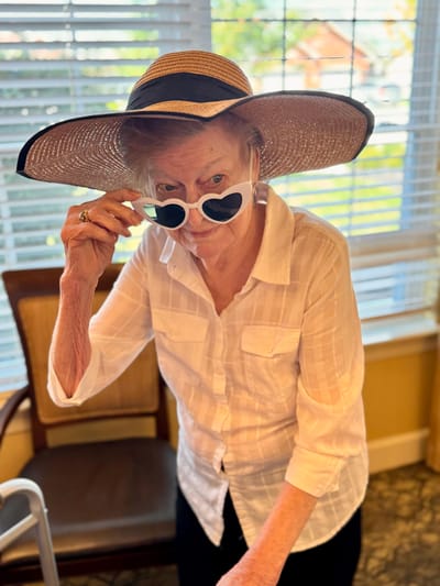 Resident wearing a sun hat and heart-shaped sunglasses