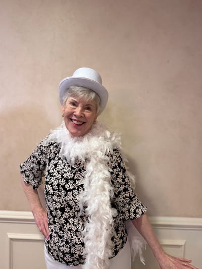 Resident dressed in a hat and feather boa at a party