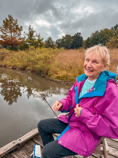 Senior woman fishing by a serene pond