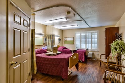 A shared resident room with two beds and seating