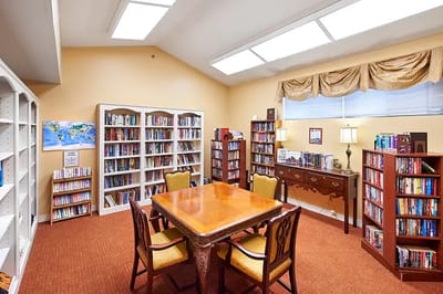 Interior of a cozy library with bookshelves and a table