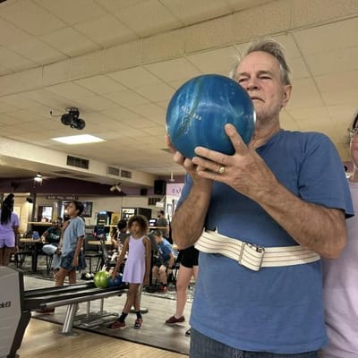 Residents participating in a bowling activity indoors