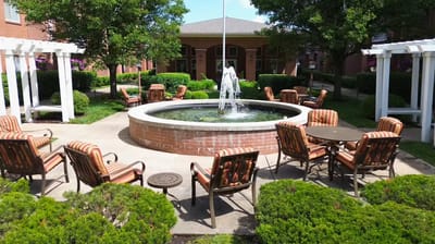 Outdoor seating area with a fountain and greenery