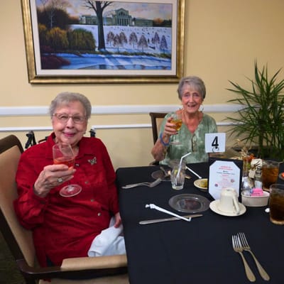 Two residents enjoying drinks at a dining table.