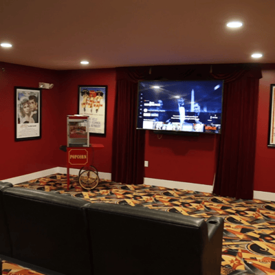 Interior of a theater room with a popcorn cart and TV