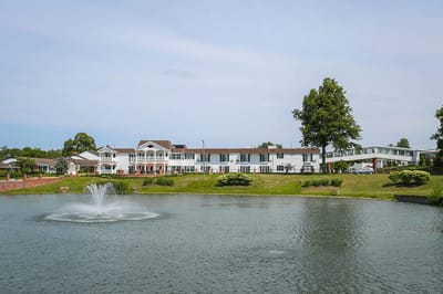 Exterior view of a retirement center by a pond