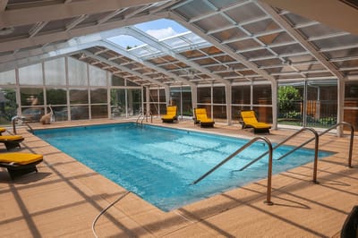 Indoor swimming pool with yellow lounge chairs
