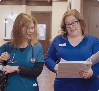 Avalon Memory Care, memory care in Fort Worth, TX — Two caregivers discussing a resident's care plan