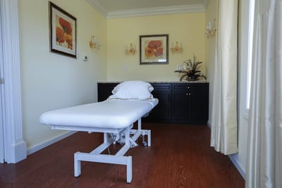 A treatment room with a massage table and decor