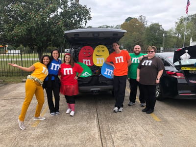 Staff members dressed as M&M characters at a community event