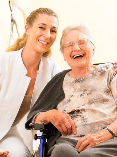A caregiver and a smiling resident in a nursing home