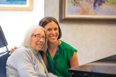 A staff member posing happily with a resident